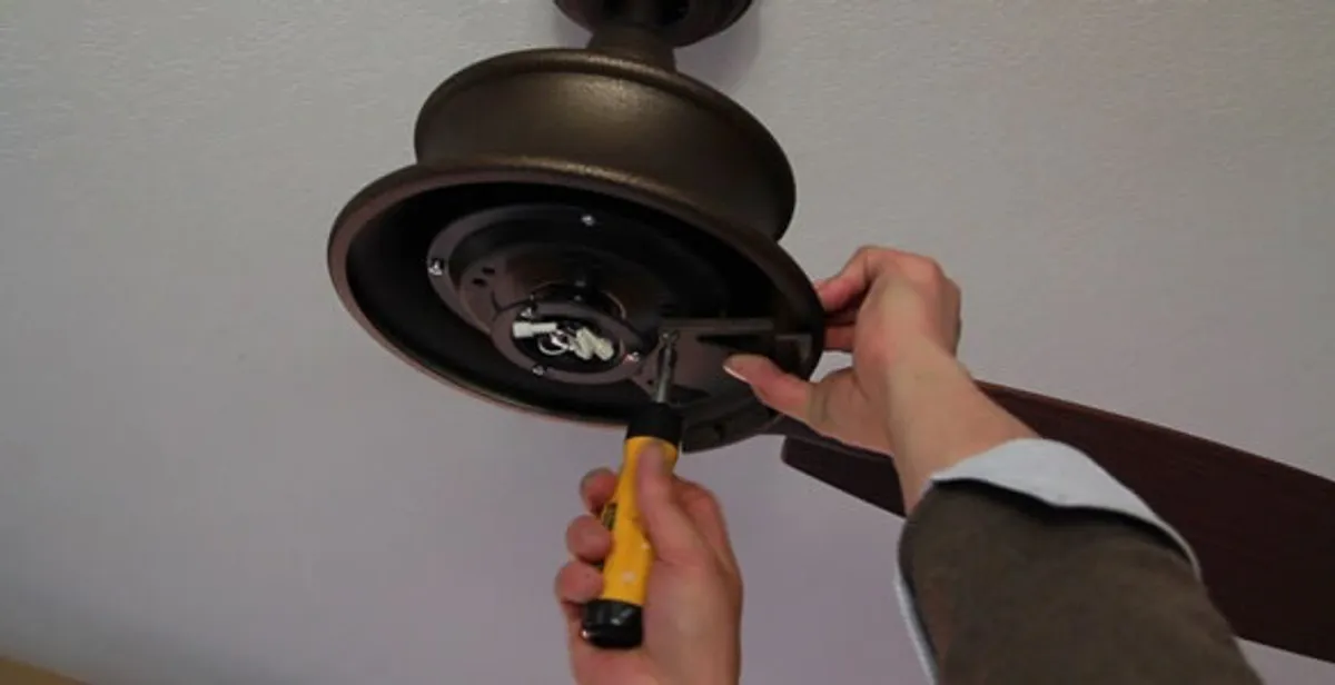 Electrician installing ceiling fan mounting bracket and fixture in Buffalo, NY